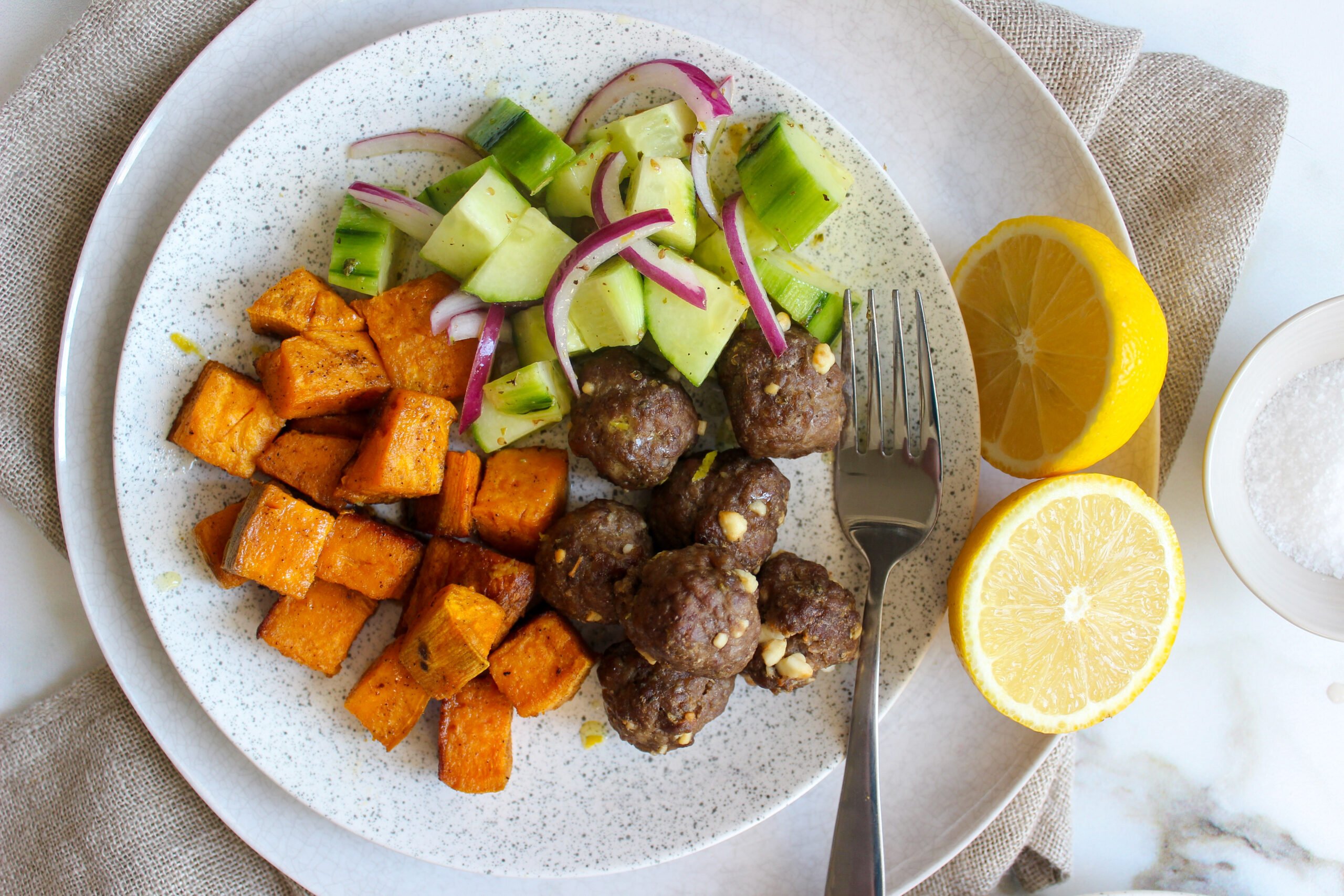 Feta-stuffed meatballs with olive and cucumber salad and roasted sweet potatoes
