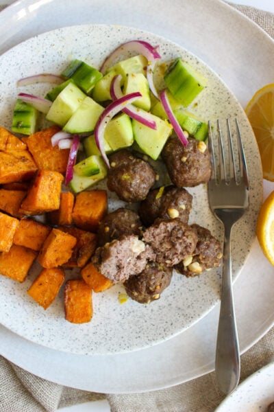 Feta-stuffed meatballs with olive and cucumber salad and roasted sweet potatoes
