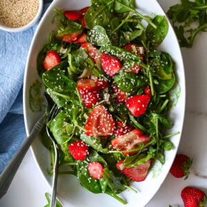 A delightful summer salad made with baby spinach, fresh strawberries and tossed with a slightly sweet vinaigrette