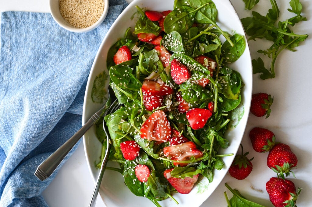 A delightful summer salad made with baby spinach, fresh strawberries and tossed with a slightly sweet vinaigrette