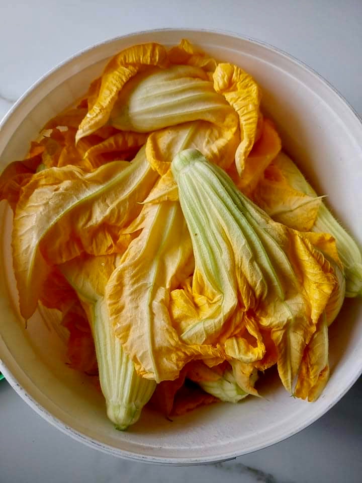 Stuffed zucchini flowers or blossoms are a vegan summer delight filled with rice, herbs and vegetables