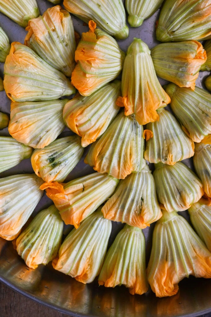 Stuffed zucchini flowers or blossoms are a vegan summer delight filled with rice, herbs and vegetables