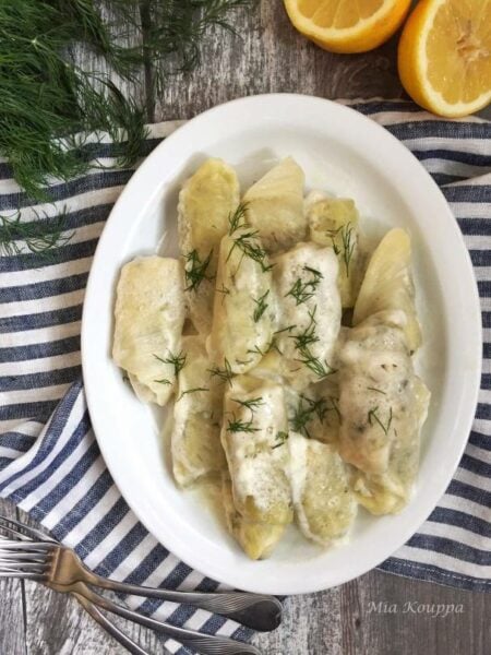 Greek cabbage rolls filled with rice, meat and herbs, topped with a rich egg lemon sauce