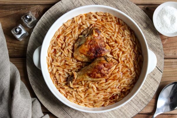 Youvetsi with chicken in pure comfort food. Tender chicken and wonderful orzo baked in a rich tomato based sauce.