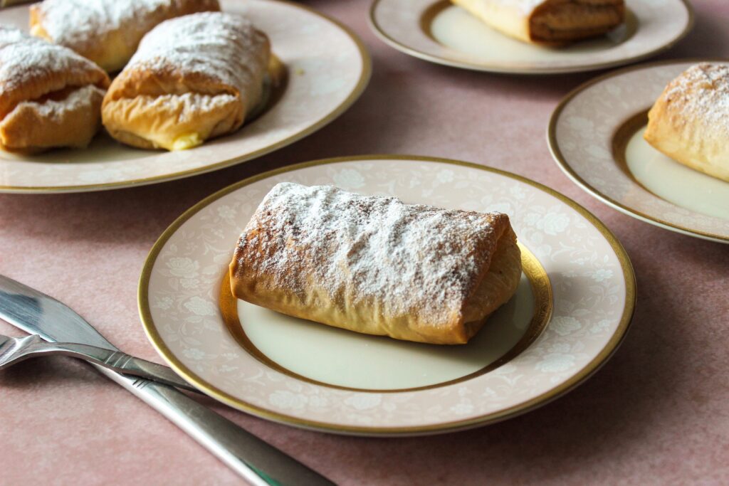 Bougatsa, cream-filled phyllo wrapped parcels sprinkled with icing sugar and cinnamon