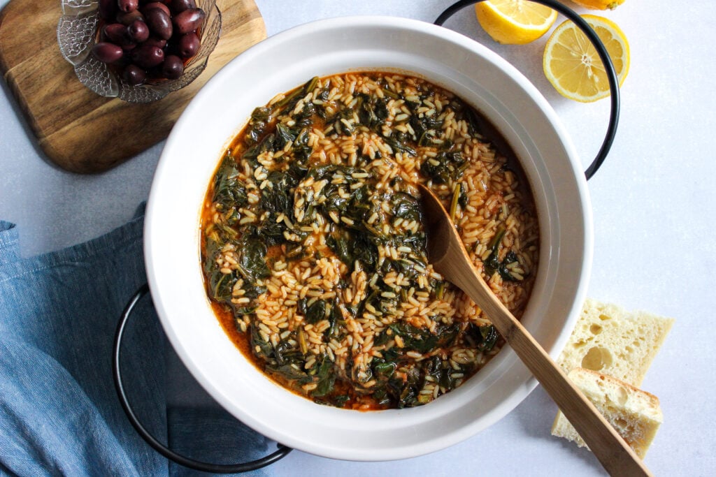 A classic recipe for Greek spanakorizo, a spinach and rice dish served in a tomato base.