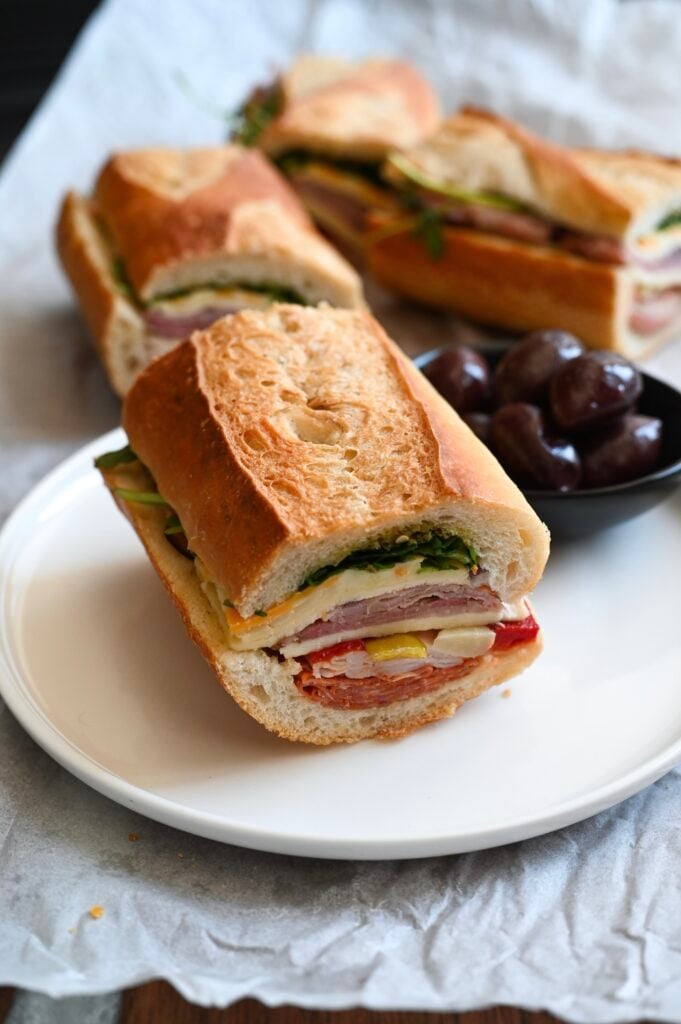 A delicious pressed sandwich full of meat, cheese, and marinated vegetables.