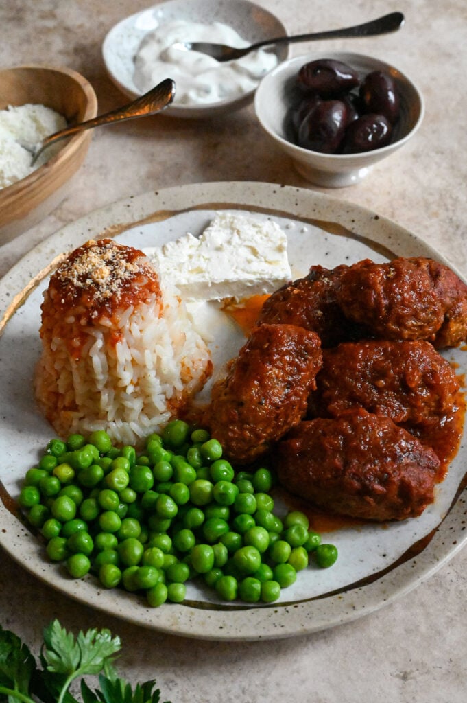 Soutzoukakia, a cross between burgers and meatballs, served in a rich tomato sauce and rice.