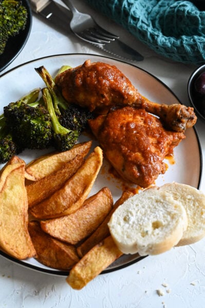 Chicken kokkinisto, or stewed chicken in a rich tomato sauce served with homemade French fries.