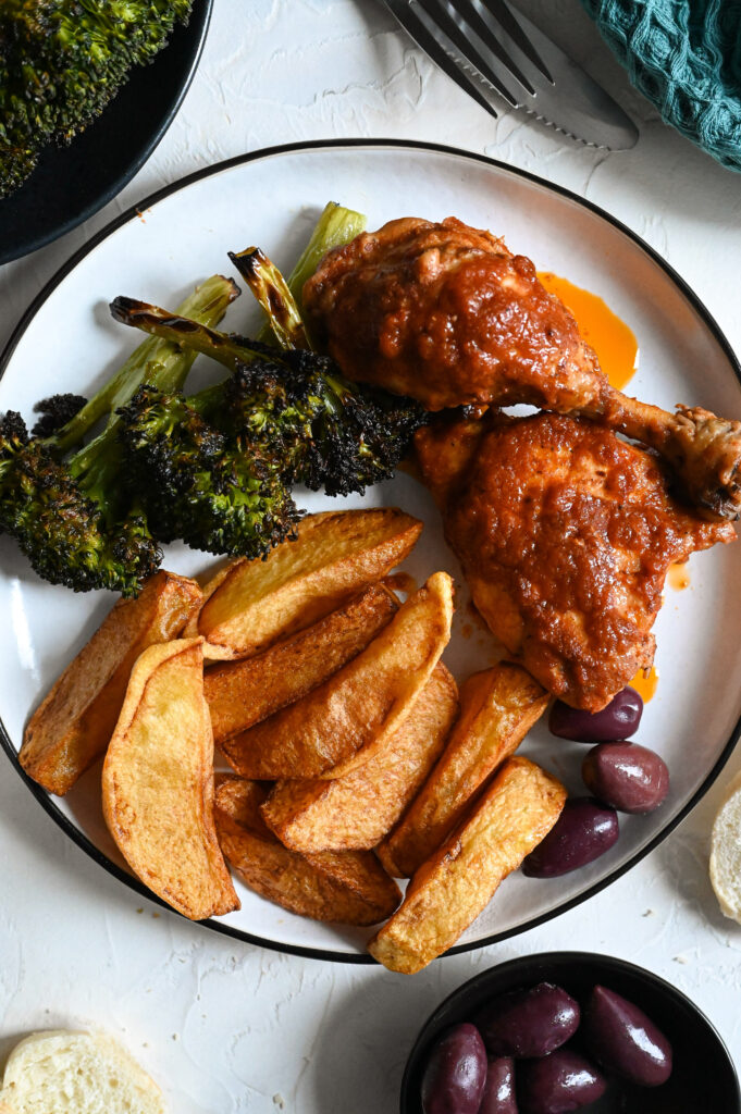 Chicken kokkinisto, or stewed chicken in a rich tomato sauce served with homemade French fries.