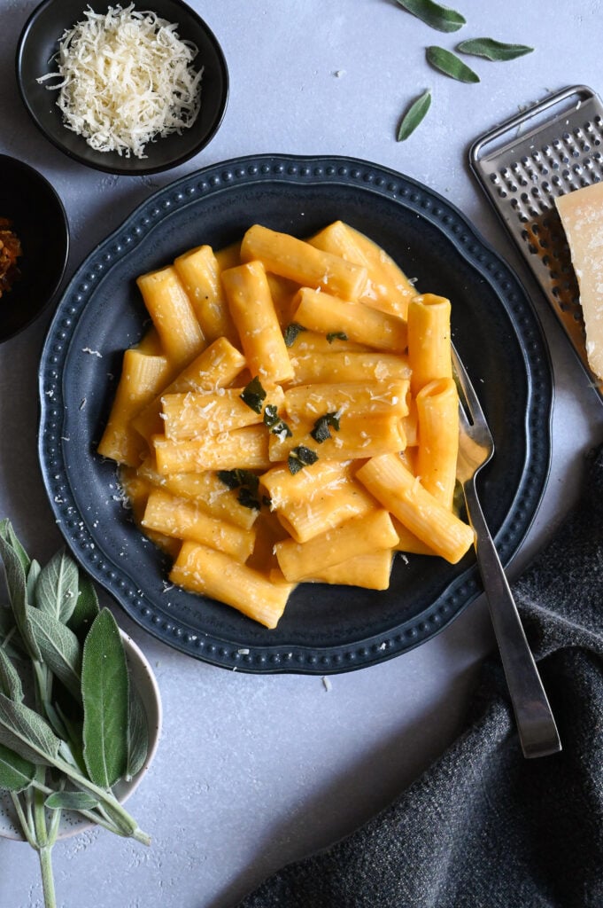 A creamy riganoti pasta topped with butternut squash sauce topped with fried sage.