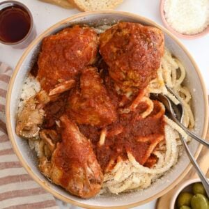 Traditional Greek recipe of rooster with pasta and rich tomato sauce or Kokora me makaronia.