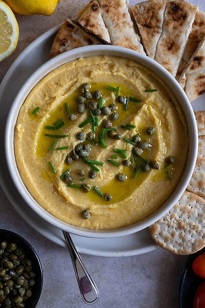Greek Fava dip or spread topped with capers, chives and drizzled with olive oil.