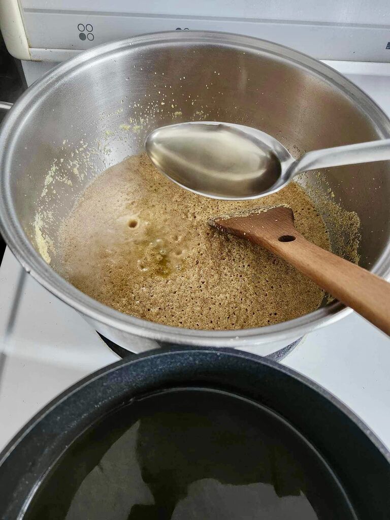 Adding syrup to the toasted semolina