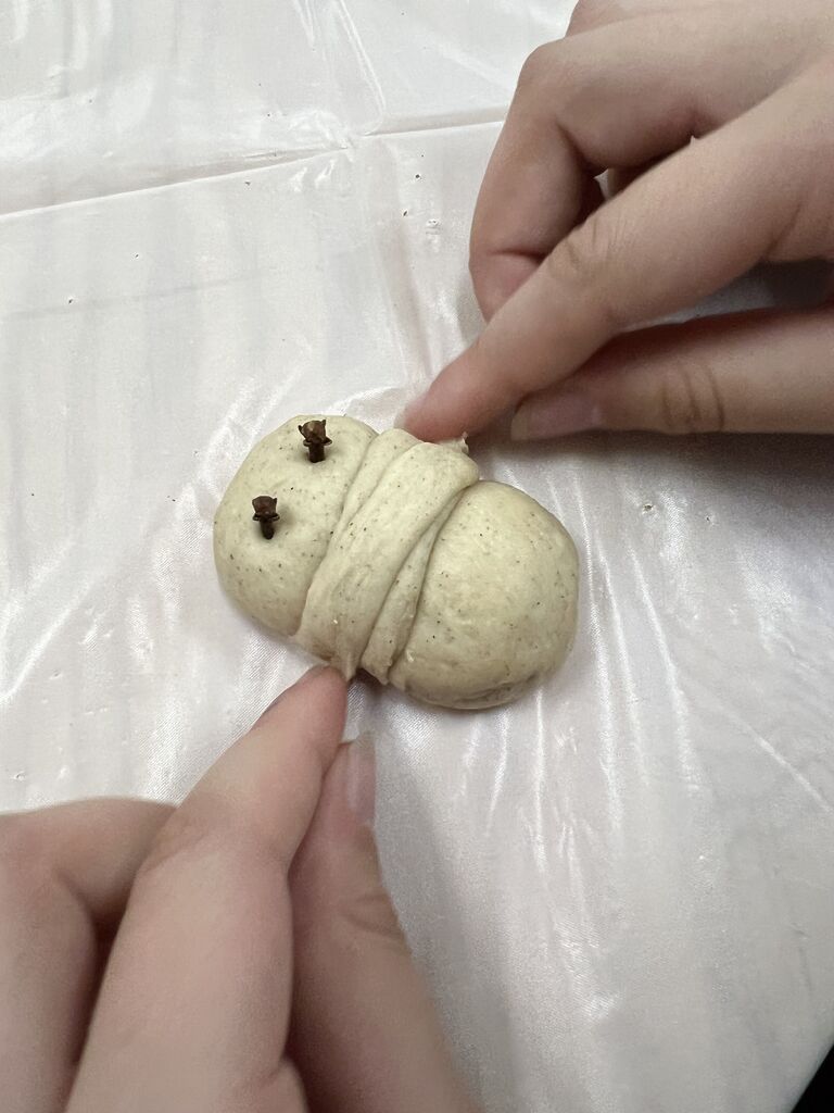 A small child shaping a lazarakia bun.