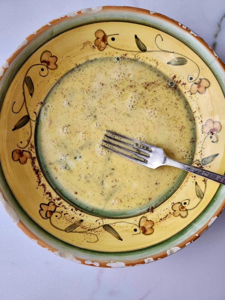 Egg and milk mixture, in a yellow flowery bowl.