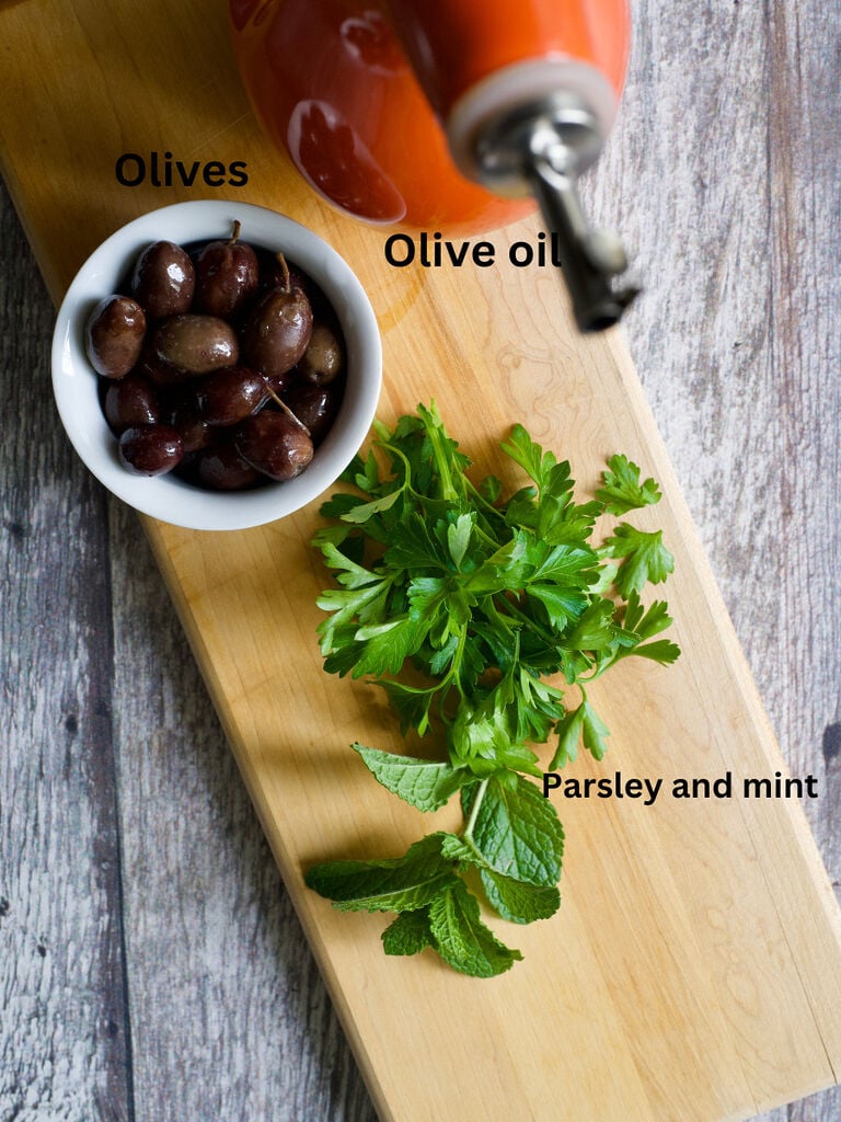 Ingredients for toppings for whipped feta dip: olives, olive oil, and parsley and mint