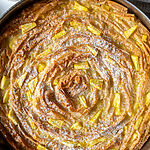 Pineapple and coconut Soufra dessert in a 10 inch stainless steel baking pan, topped with icing sugar.