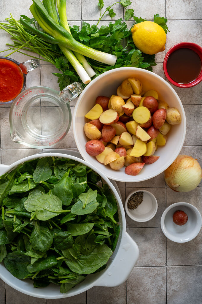 Ingredients for the spinach and potato stew, tomato sauce, water, green onions, parsley, lemon, olive oil, potatoes, salt and pepper, tomato paste, onion and spinach.