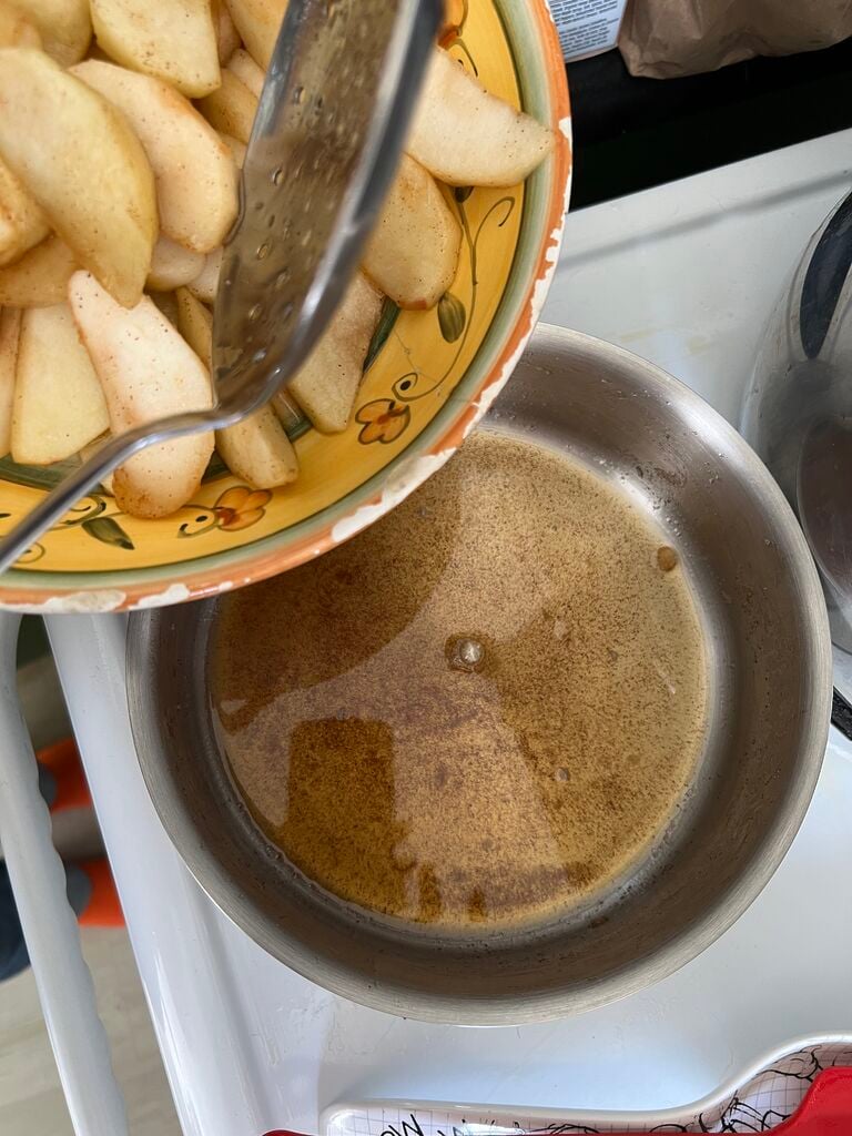 Removing the cooked apples from pot.