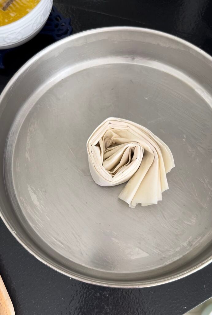 Folding the phyllo (filo) and placing in pan in circles.