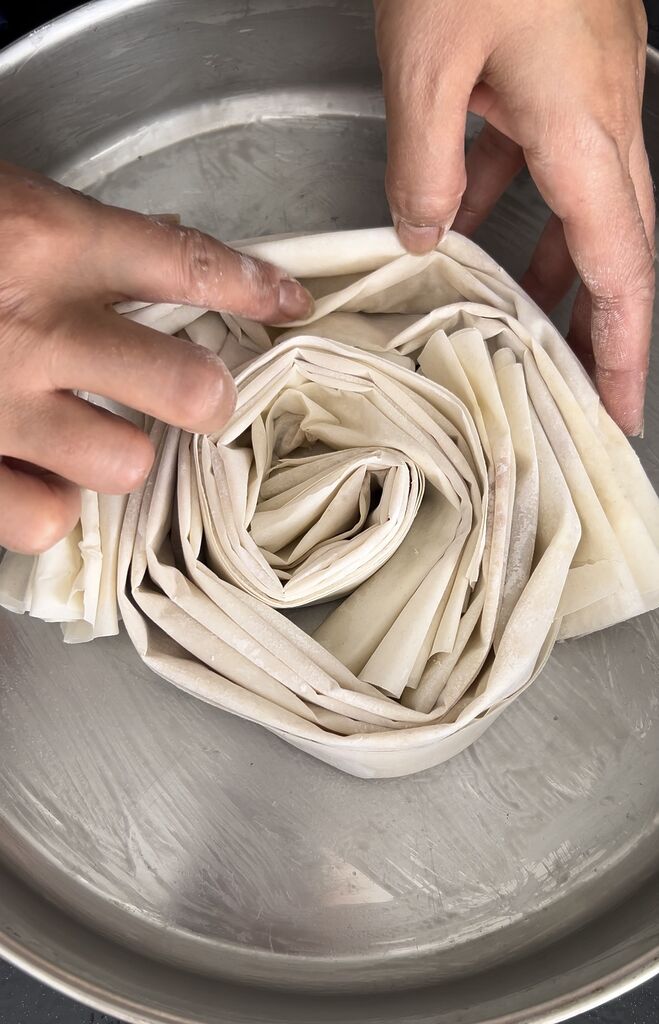 Folding the phyllo(filo) and placing in pan in circles.