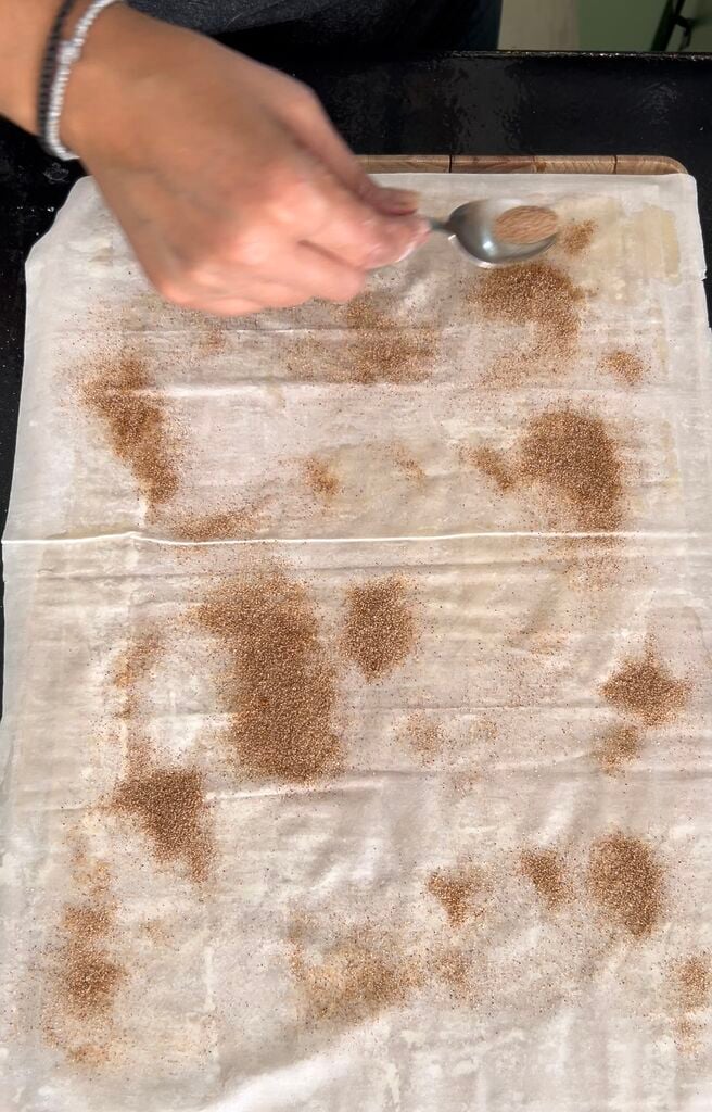 Adding cinnamon sugar to the phyllo (filo).
