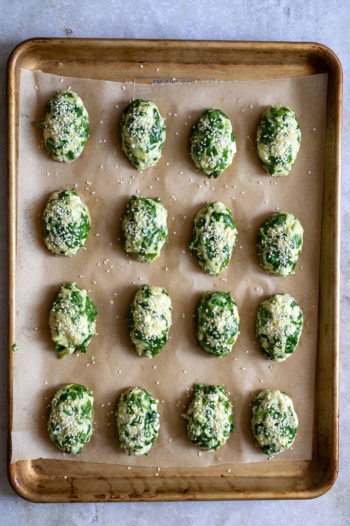 Greek Spanakotiropitakia (spinach and cheese pita) without phyllo, on a baking pan, ready to go in oven.