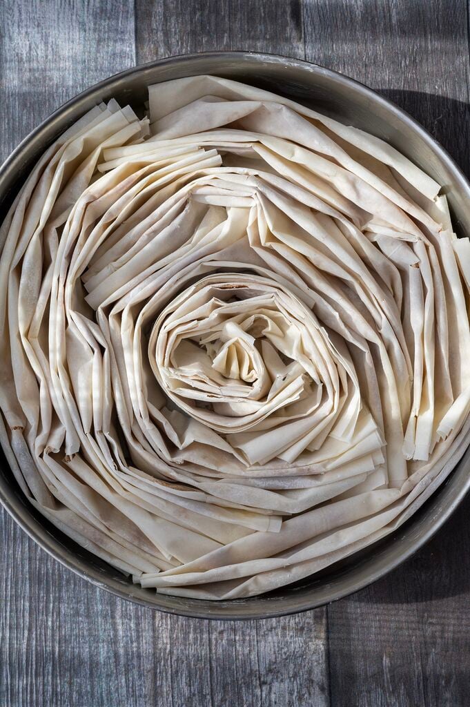 The phyllo (filo) ready to be baked in a stainless steel pan.