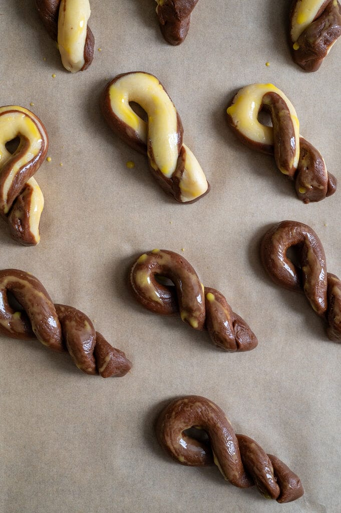 Greek butter koulourakia with a chocolate twist on a baking tray.