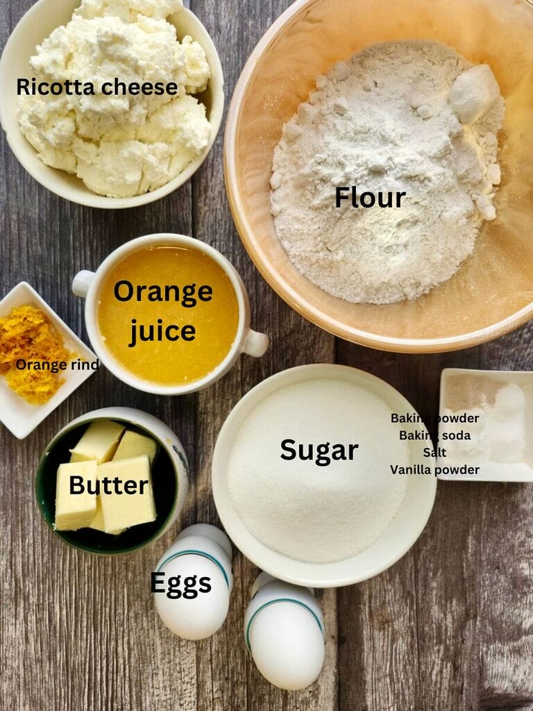 Ingredients for orange ricotta cookies which include: Ricotta cheese, flour, orange juice, orange rind, butter, eggs, sugar, baking powder, baking soda, salt and vanilla powder