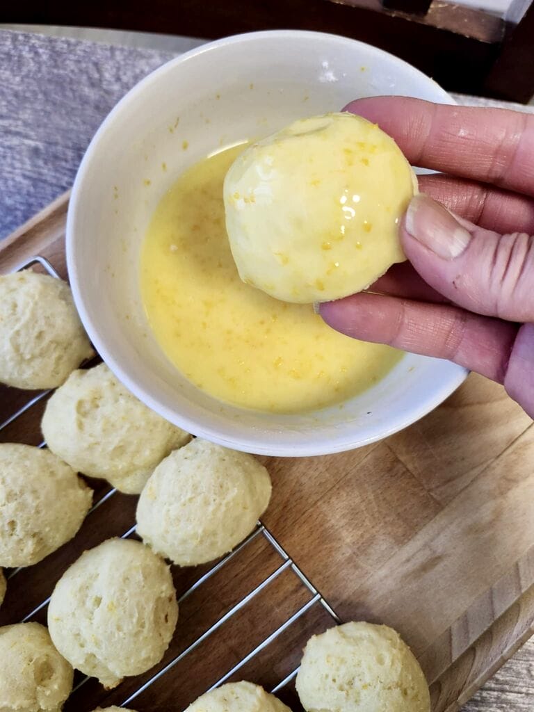 Dipping the cookie into the glaze.