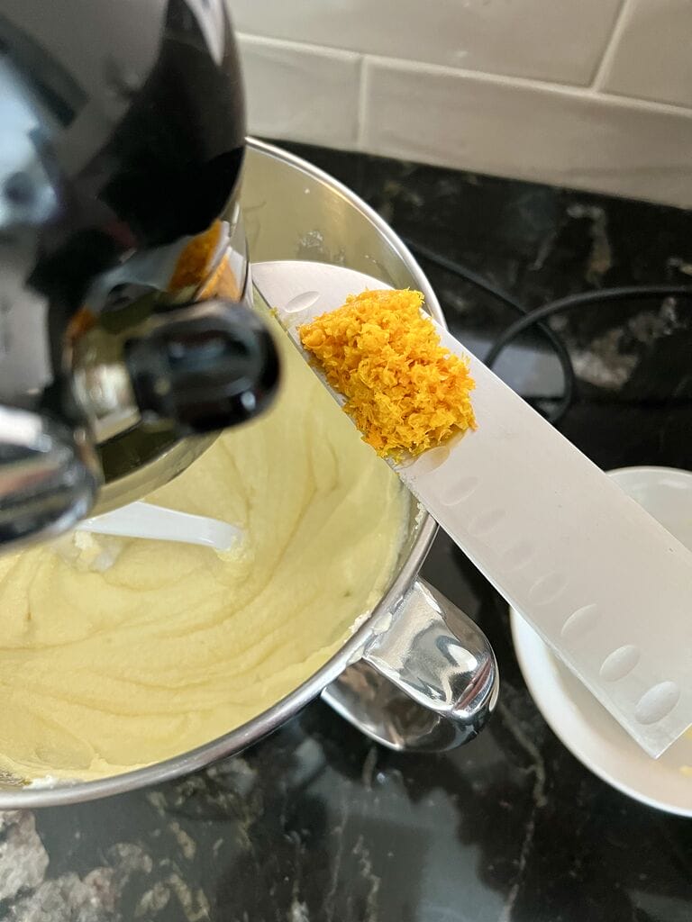 Adding the orange rind into the batter.