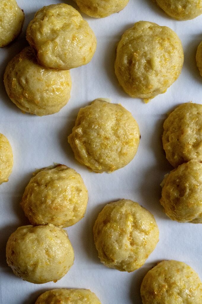 Orange ricotta cookies on parchment paper.