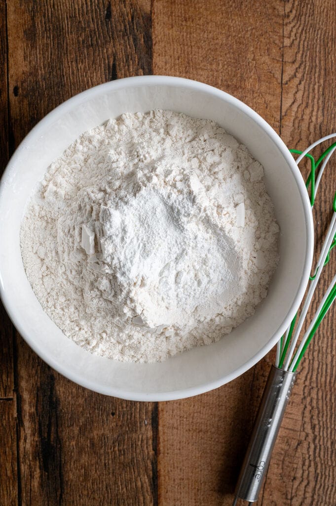 Whisking together the flour, baking powder and pinch of salt, in a white bowl.