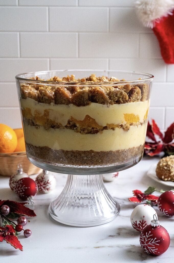 Layering the Greek melomakarona trifle in a glass trifle bowl.