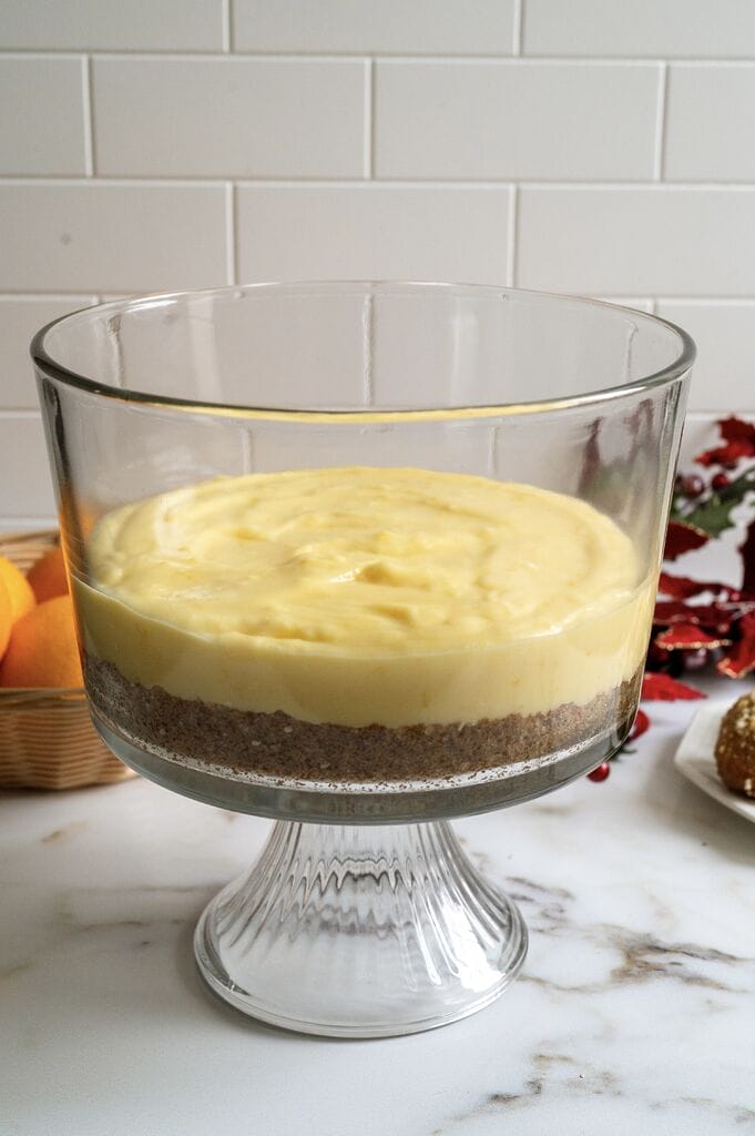 Layering the Greek melomakarona trifle in a glass trifle bowl.