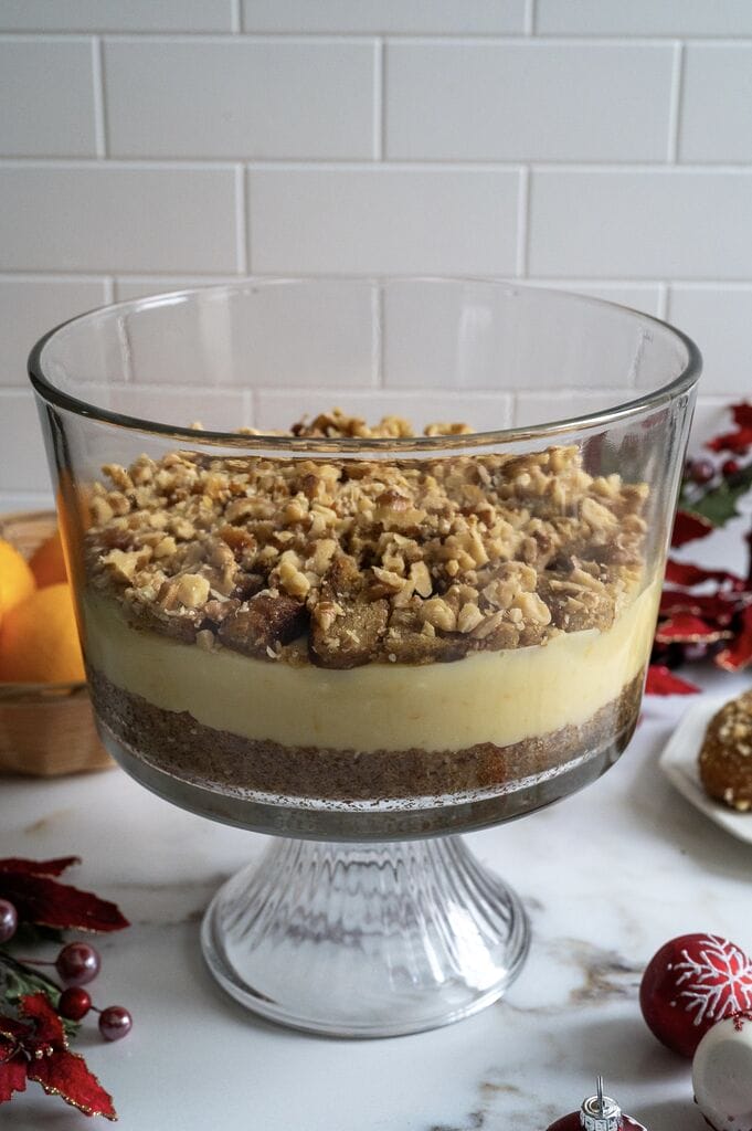 Layering the Greek melomakarona trifle in a glass trifle bowl.