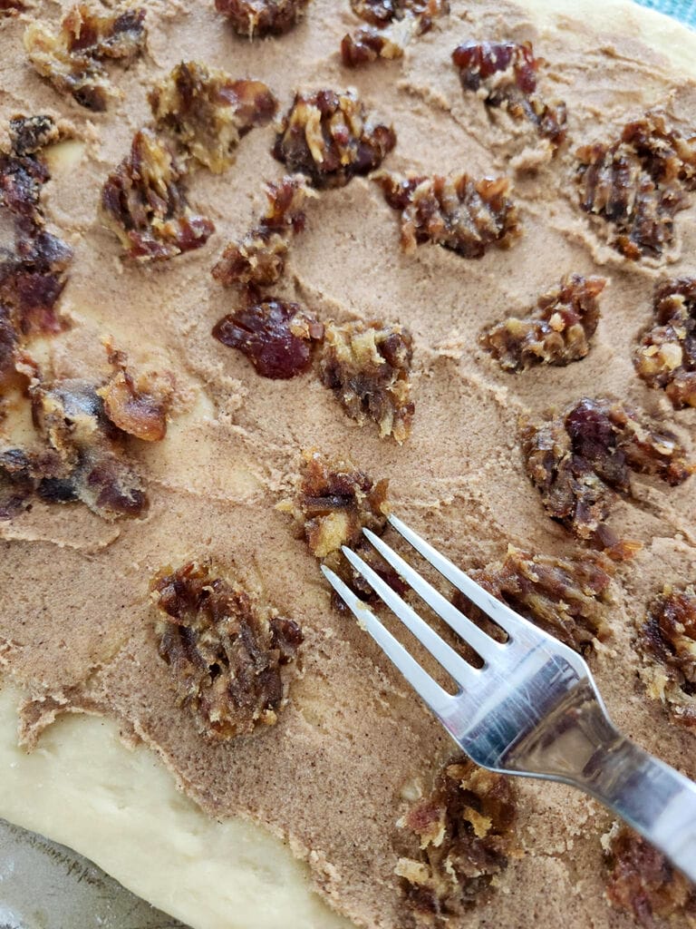 Pressing down the dates onto the sugar mixture.