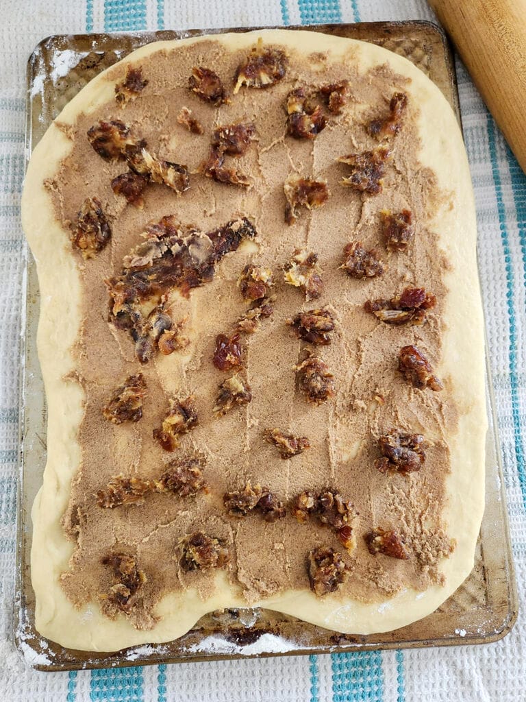 The dough laid flat topped with brown sugar mixture and dates.