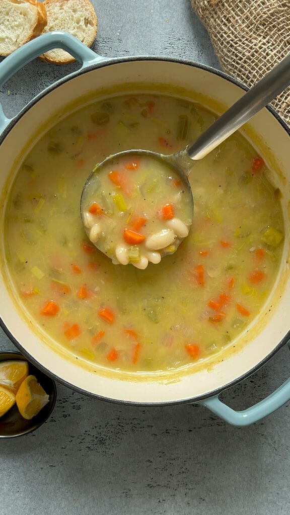 Fasolatha soup in a blue cast iron pot.