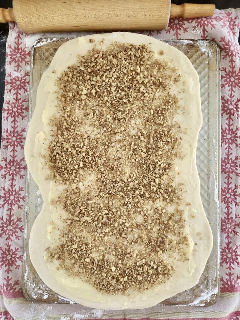 Adding a layer of the mixture on top of the dough.