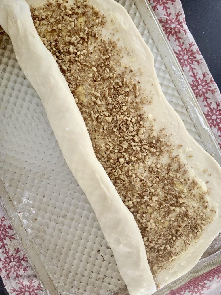 Rolling the dough of the cinnamon rolls.