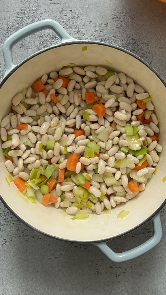 Adding the kidney beans to the vegetable mixture.