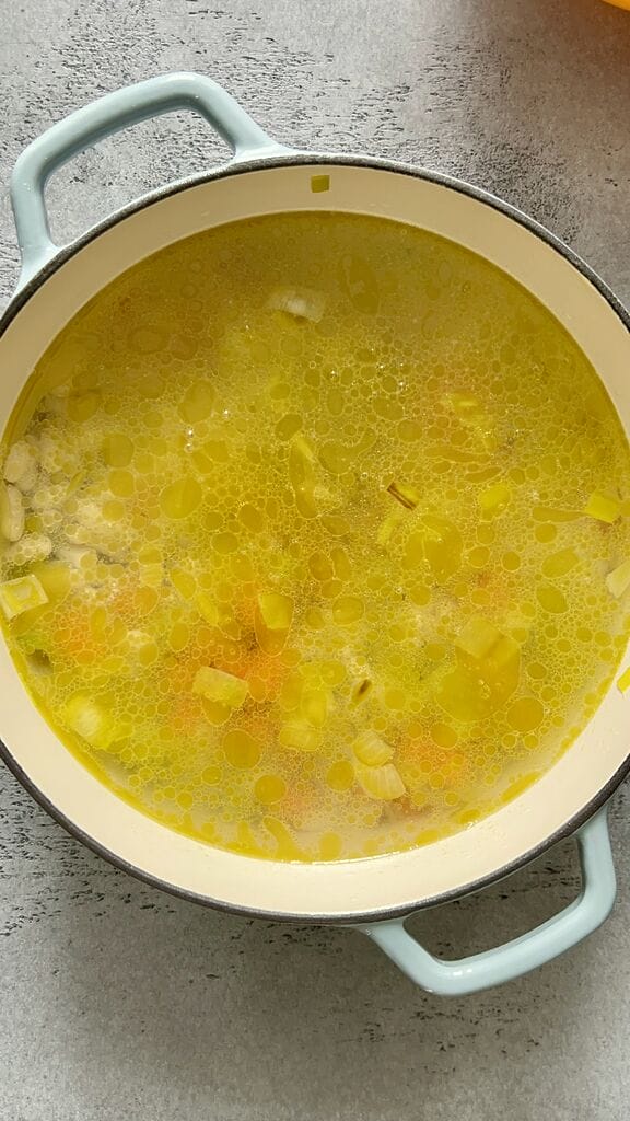 Fasolatha soup in a blue cast iron pot.