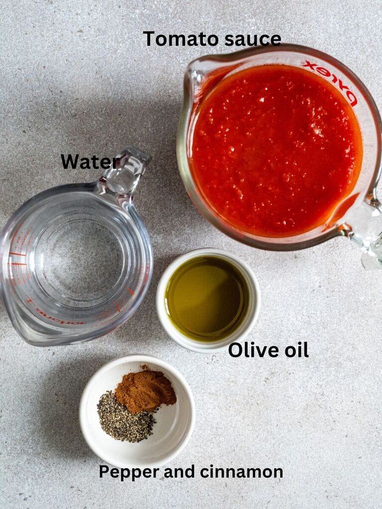 Ingredients for soutzoukakia with rice: Tomato sauce, water, olive oil, pepper and cinnamon