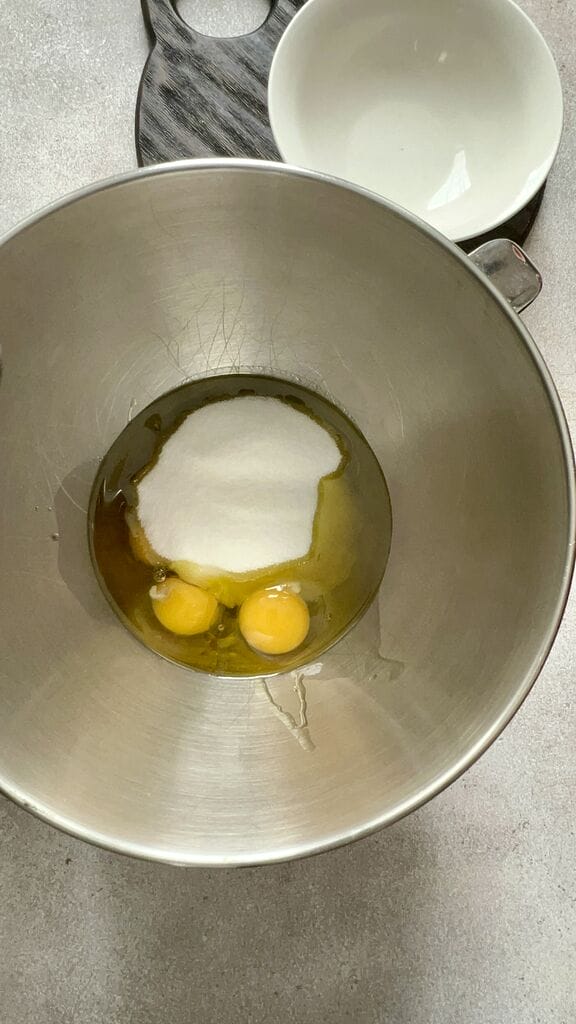 Adding the sugar and eggs in mixing bowl.