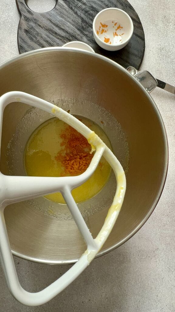 Adding the orange zest to the sugar and egg mixture.