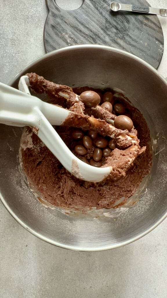 Adding the chocolate covered almonds to the dough.