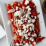Roasted red pepper and feta salad on a white plate.